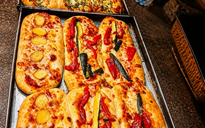 Le lingue Kotit: focacce lunghe alle zucchine, patate e verdure appena sfornate, all'ingrosso a Milano