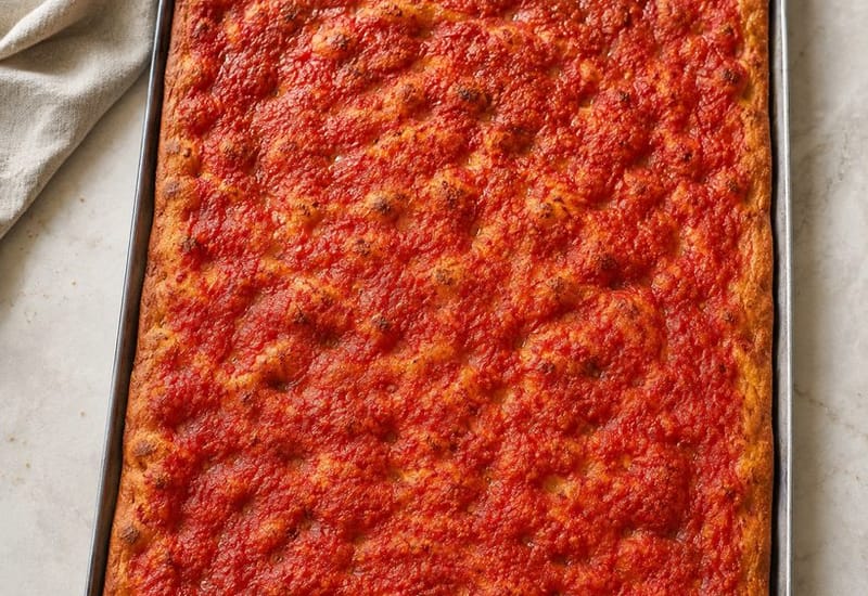 Teglia di pizza rossa con pomodoro e origano